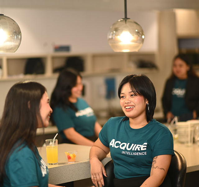People in matching teal shirts socializing.